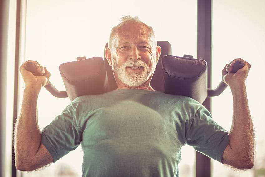 A strong Senior male training at the gym