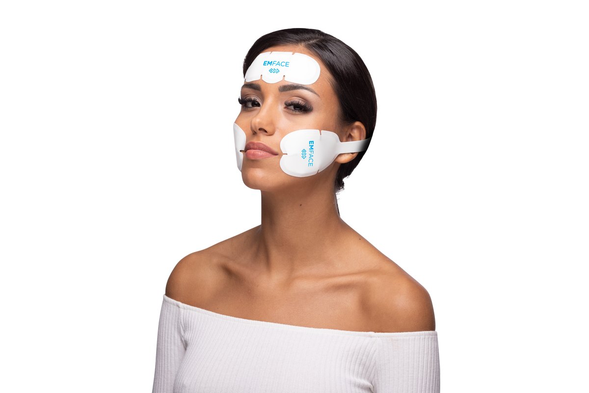 Woman wearing EMFACE applicators on her forehead and cheeks